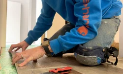 Martin Wipf applies new flooring in a house remodel