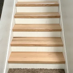 Refinished wood staircase with white paneling